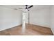 A bright bedroom featuring hardwood flooring, ceiling fan, and an open doorway at 8512 Longboat Ln, Hudson, FL 34667