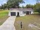Aerial view of home featuring mature landscaping and attached one-car garage at 8512 Longboat Ln, Hudson, FL 34667