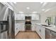 Updated kitchen featuring stainless appliances, quartz countertops, and subway tile backsplash at 8512 Longboat Ln, Hudson, FL 34667