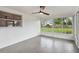Sunroom with large windows offering backyard views, with ceiling fan and light gray tile flooring at 8512 Longboat Ln, Hudson, FL 34667