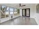 Bright sunroom with multiple windows, ceiling fan, gray tile floors, and access to the backyard at 8512 Longboat Ln, Hudson, FL 34667