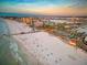 Scenic aerial view captures the white sandy beach, pier, and cityscape at sunset at 864 Mandalay Ave, Clearwater Beach, FL 33767
