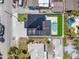Aerial view of a modern home featuring a dark roof, pool, outdoor turf, and a spacious paved driveway at 864 Mandalay Ave, Clearwater Beach, FL 33767