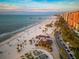 Gorgeous aerial view of a white sand beach with palm trees, buildings, and a long pier at 864 Mandalay Ave, Clearwater Beach, FL 33767