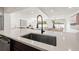Modern kitchen island with stainless steel sink and faucet, and views of the open living area and backyard pool at 864 Mandalay Ave, Clearwater Beach, FL 33767