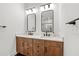 Modern bathroom featuring double vanity, wood cabinets, black hardware, and modern mirrors at 8720 Drummer Plank Dr, Wesley Chapel, FL 33545