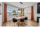 Bright dining room with modern table and chairs, wooden floors, and pool view from large windows at 8720 Drummer Plank Dr, Wesley Chapel, FL 33545