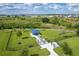 Aerial view of the fenced dog park with playground equipment and shaded seating area at 8720 Drummer Plank Dr, Wesley Chapel, FL 33545