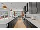 Spacious kitchen featuring black cabinets, stainless appliances, quartz countertops, and an adjacent dining area at 8720 Drummer Plank Dr, Wesley Chapel, FL 33545
