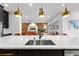 Modern kitchen island with stainless sink, white marble countertop, and seating for entertaining guests at 8720 Drummer Plank Dr, Wesley Chapel, FL 33545