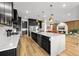 Open kitchen with large island, stainless steel appliances, white marble counters, and an open view to the living room at 8720 Drummer Plank Dr, Wesley Chapel, FL 33545