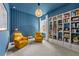 Bright living room with blue walls, yellow chairs, and a bookcase at 8720 Drummer Plank Dr, Wesley Chapel, FL 33545