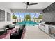 Poolside view with a covered outdoor kitchen and modern seating area at 8720 Drummer Plank Dr, Wesley Chapel, FL 33545
