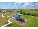 Playground featuring slides, swings, picnic tables, and a covered area surrounded by a sidewalk at 8720 Drummer Plank Dr, Wesley Chapel, FL 33545