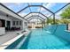 Enjoy the sunny pool with a waterfall feature, in-pool loungers, and an ample patio area under a screened enclosure at 8720 Drummer Plank Dr, Wesley Chapel, FL 33545