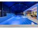 Stunning screened pool area with a waterfall feature, sun shelves, and an outdoor kitchen at 8720 Drummer Plank Dr, Wesley Chapel, FL 33545