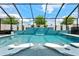 This stunning pool features a cascading waterfall, in-pool loungers, and ample patio seating under a screened enclosure at 8720 Drummer Plank Dr, Wesley Chapel, FL 33545