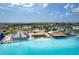 Aerial view of a clear lagoon with buildings, cabanas, and a sandy beach and plenty of activities at 8720 Drummer Plank Dr, Wesley Chapel, FL 33545