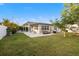 The backyard features a well-maintained lawn and mature trees creating a serene outdoor space at 8801 Sunlit Cove Ne Dr, St Petersburg, FL 33702