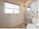 Bathroom featuring a window, toilet, and mosaic-tile walls at 8801 Sunlit Cove Ne Dr, St Petersburg, FL 33702