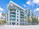 Contemporary condo building featuring multiple stories, glass balconies, and lush palm trees at 912 Channelside Dr # 2501, Tampa, FL 33602