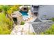 Aerial view of backyard pool with rock feature, outdoor kitchen, and firepit at 9607 Orange Jasmine Way, Tampa, FL 33647