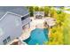 A view of the backyard featuring a covered seating area, a rock waterfall pool and lush landscaping at 9607 Orange Jasmine Way, Tampa, FL 33647