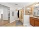 Bathroom with a walk-in shower with tiled surround and glass enclosure, and a granite countertop vanity at 9607 Orange Jasmine Way, Tampa, FL 33647