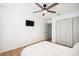 Bright bedroom showcasing wood-look floors, ceiling fan, and double closet at 9607 Orange Jasmine Way, Tampa, FL 33647