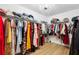 Organized walk-in closet with hanging rods, shelves, and a chandelier, maximizing storage space at 9607 Orange Jasmine Way, Tampa, FL 33647