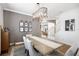 Elegant dining room featuring a modern chandelier, seating for six, and contemporary decor at 9607 Orange Jasmine Way, Tampa, FL 33647