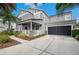 Charming two-story home with a front porch, a two-car garage, and landscaped yard at 9607 Orange Jasmine Way, Tampa, FL 33647