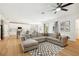 Open-concept living room with a large sectional sofa, wood floors and a view of the kitchen at 9607 Orange Jasmine Way, Tampa, FL 33647