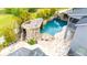 An elevated view of the luxurious pool featuring a rock waterfall and sun loungers, perfect for relaxation at 9607 Orange Jasmine Way, Tampa, FL 33647