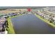 Wide aerial view showcasing houses near large lake with beautiful green space, and serene water views at 10008 Celtic Ash Dr, Ruskin, FL 33573
