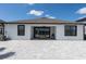 Rear view of a patio with sliding glass doors, picnic table and grill, with paved surface at 10008 Celtic Ash Dr, Ruskin, FL 33573