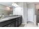Bathroom featuring double sinks, granite countertop and tiled shower at 10008 Celtic Ash Dr, Ruskin, FL 33573