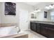 Bathroom features double sinks, a soaking tub, and stylish granite countertops at 10008 Celtic Ash Dr, Ruskin, FL 33573