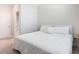 Bright, carpeted bedroom with a white bed and a door leading to an attached bathroom at 10008 Celtic Ash Dr, Ruskin, FL 33573