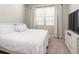 Bright bedroom featuring large window and a modern TV console and white bedding at 10008 Celtic Ash Dr, Ruskin, FL 33573