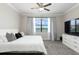 A comfortable bedroom with a large window, TV, soft carpet, and neutral decor at 10008 Celtic Ash Dr, Ruskin, FL 33573