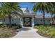 Charming clubhouse entrance with lush landscaping and palm trees on a sunny day at 10008 Celtic Ash Dr, Ruskin, FL 33573