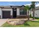 Charming home featuring a well-manicured lawn, stone accents, and a cozy front entrance at 10008 Celtic Ash Dr, Ruskin, FL 33573