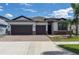 Charming single-story home with a well-manicured lawn, brick-paved driveway, and a three-car garage at 10008 Celtic Ash Dr, Ruskin, FL 33573