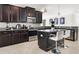Modern kitchen with dark cabinets, stainless steel appliances, and an island with seating at 10008 Celtic Ash Dr, Ruskin, FL 33573