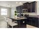 Well-equipped kitchen with dark cabinets, stainless steel appliances, and a breakfast island at 10008 Celtic Ash Dr, Ruskin, FL 33573