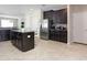 This well-lit kitchen showcases dark cabinets, stainless steel appliances, an island, and a view into the dining area at 10008 Celtic Ash Dr, Ruskin, FL 33573