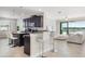 Open-concept kitchen with dark cabinets, granite countertops, bar seating, and view to living area at 10008 Celtic Ash Dr, Ruskin, FL 33573