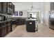 A well-lit kitchen features dark cabinets, granite countertops, stainless steel appliances, and an island with bar seating at 10008 Celtic Ash Dr, Ruskin, FL 33573