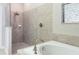 Tiled bathroom showing shower and tub with modern fixtures and window at 10008 Celtic Ash Dr, Ruskin, FL 33573